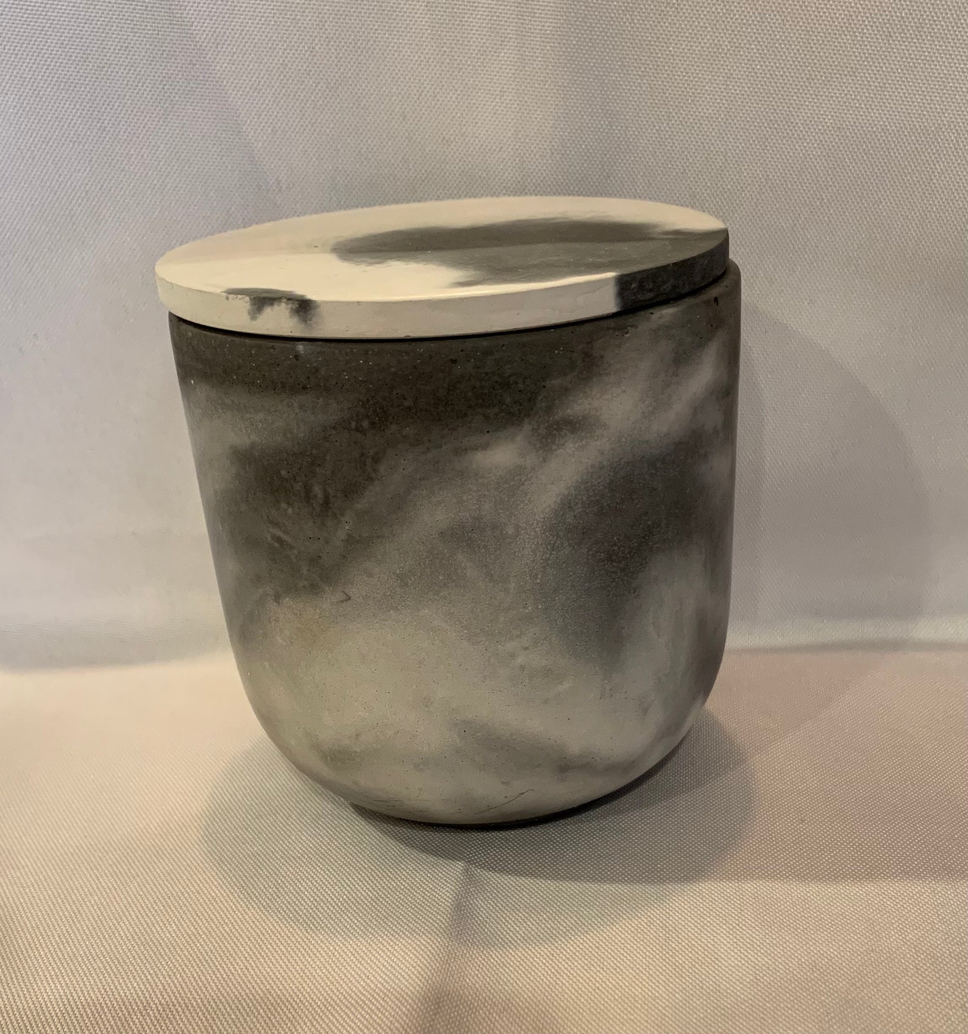 Marble-patterned container with a lid on a gray background